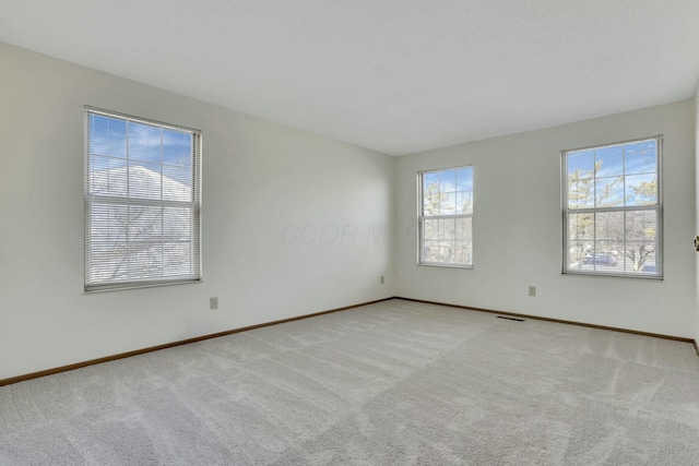 empty room featuring baseboards, visible vents, and carpet floors