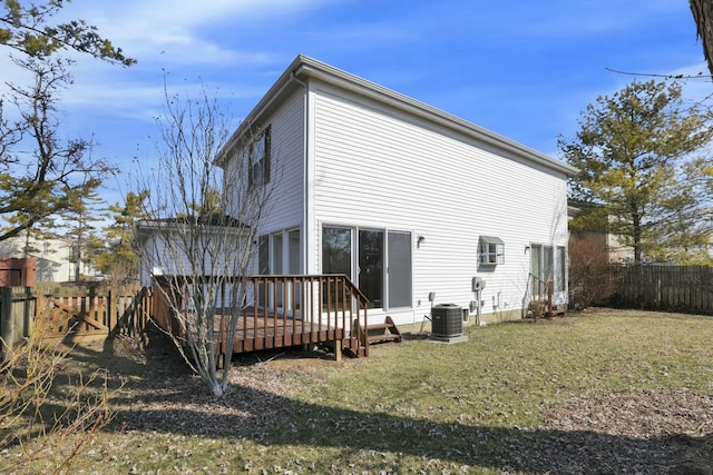 rear view of house featuring central air condition unit, a deck, a lawn, and a fenced backyard