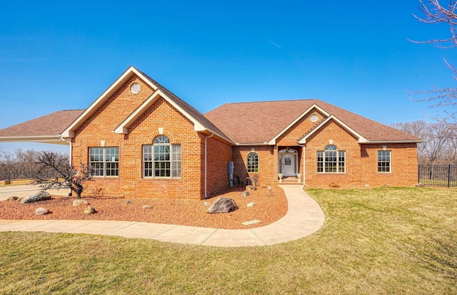 single story home with brick siding, roof with shingles, a front yard, and fence