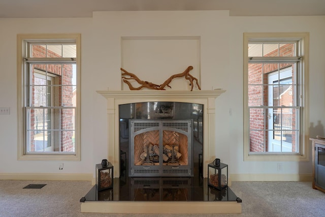 details featuring visible vents, baseboards, a fireplace, and carpet flooring