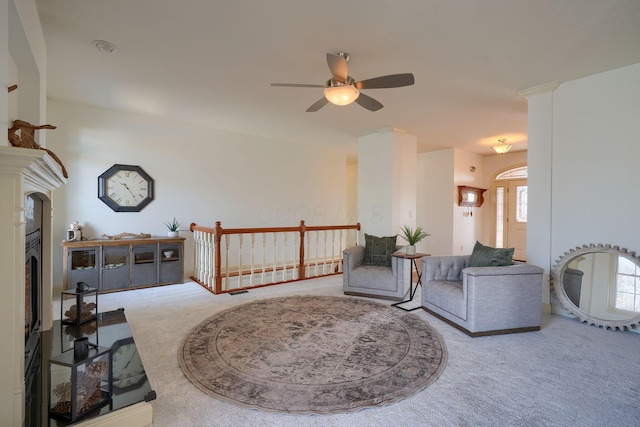 sitting room with a ceiling fan and carpet flooring