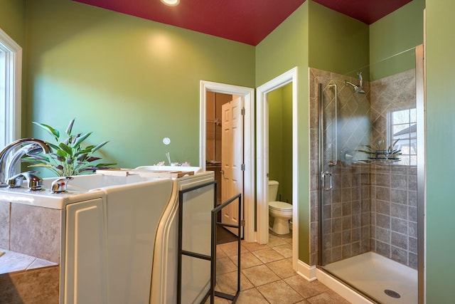 bathroom with tile patterned flooring, a stall shower, toilet, and a bath