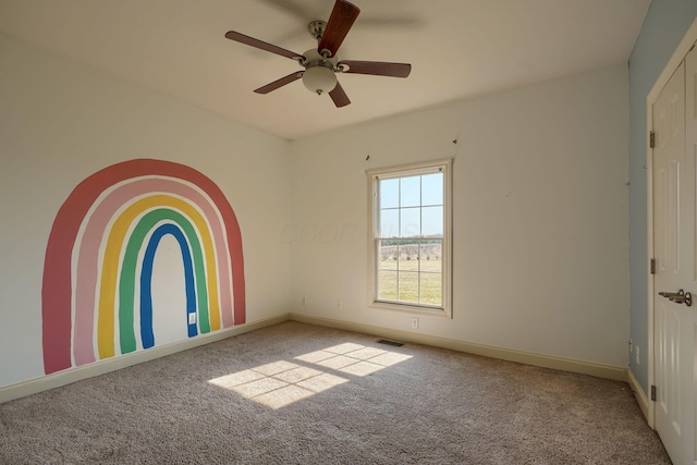 empty room featuring carpet flooring, visible vents, baseboards, and ceiling fan