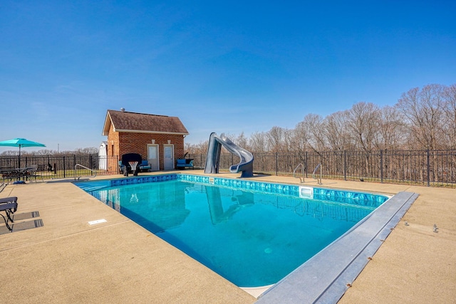 view of swimming pool with a patio, fence, a fenced in pool, a water slide, and an outdoor structure