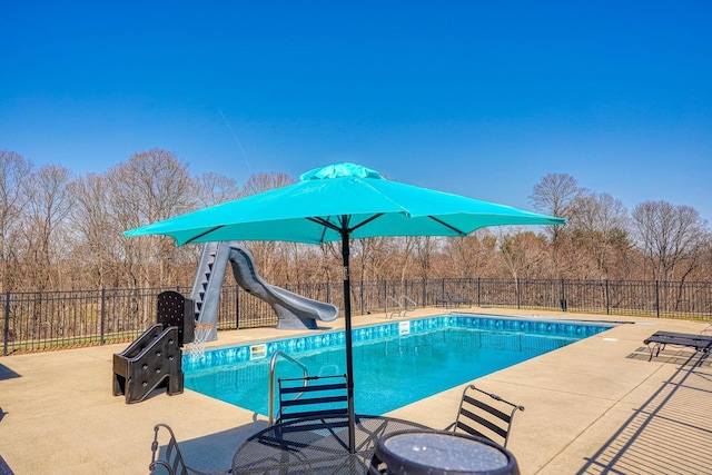 view of swimming pool featuring a fenced in pool, a patio area, a water slide, and fence