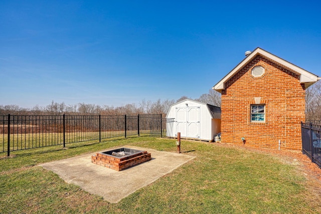 view of yard featuring a fire pit, a storage shed, a fenced backyard, an outbuilding, and a patio