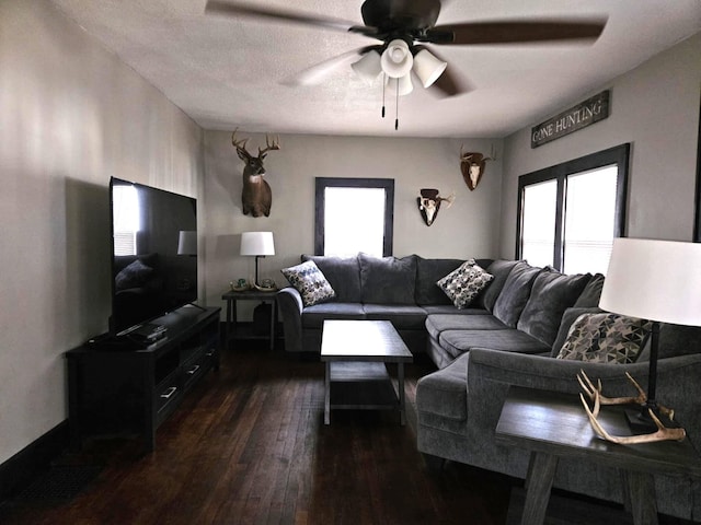 living room featuring dark wood finished floors and a ceiling fan