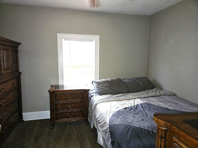 bedroom with baseboards and dark colored carpet