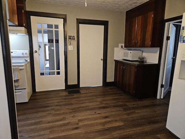 kitchen featuring dark wood-style floors, white appliances, dark countertops, and exhaust hood