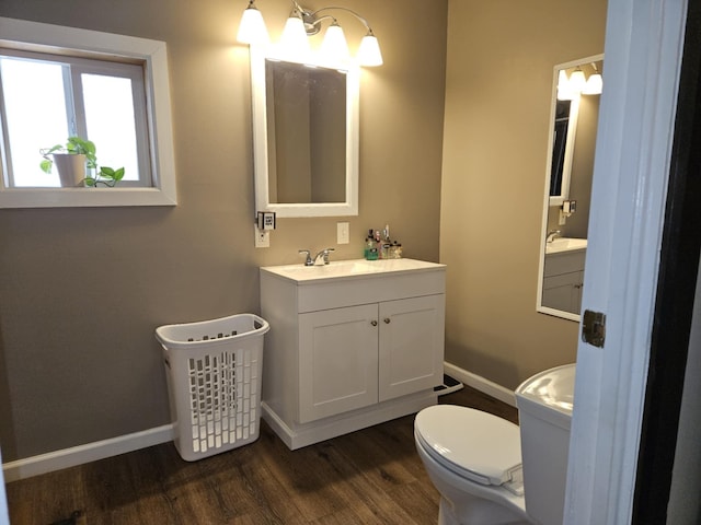 bathroom featuring vanity, toilet, wood finished floors, and baseboards