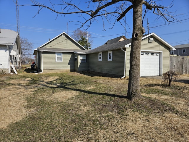 back of house featuring a yard, driveway, a garage, and fence