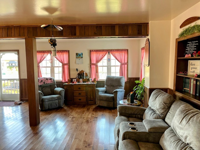 living room with a wainscoted wall, wood walls, a healthy amount of sunlight, and hardwood / wood-style floors