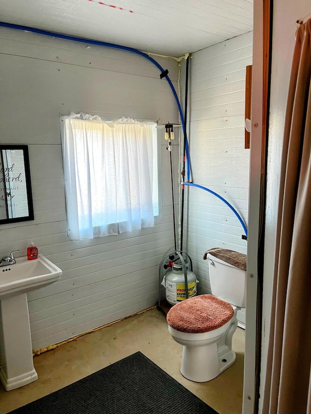 bathroom featuring toilet and concrete flooring