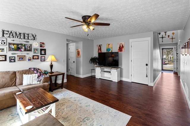 living room featuring a textured ceiling, baseboards, ceiling fan, and wood finished floors