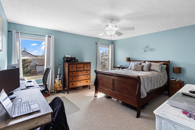 carpeted bedroom with ceiling fan and a textured ceiling