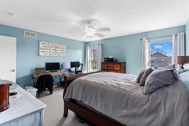 bedroom featuring visible vents, multiple windows, a ceiling fan, and carpet floors