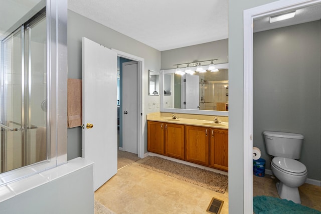 bathroom with a sink, visible vents, double vanity, and a shower stall