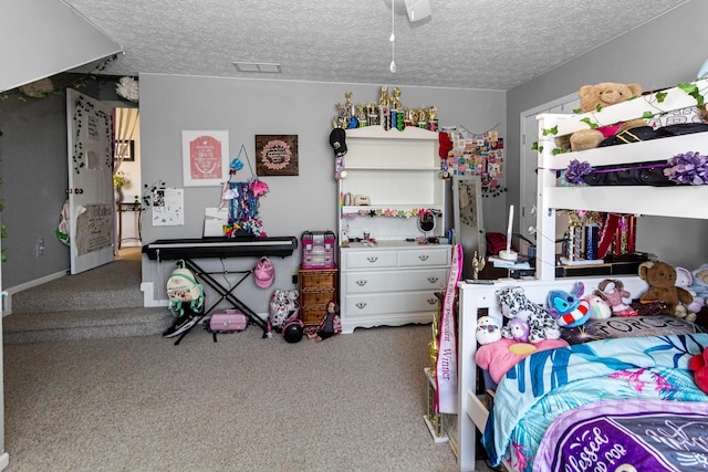 carpeted bedroom with visible vents, a textured ceiling, and a ceiling fan