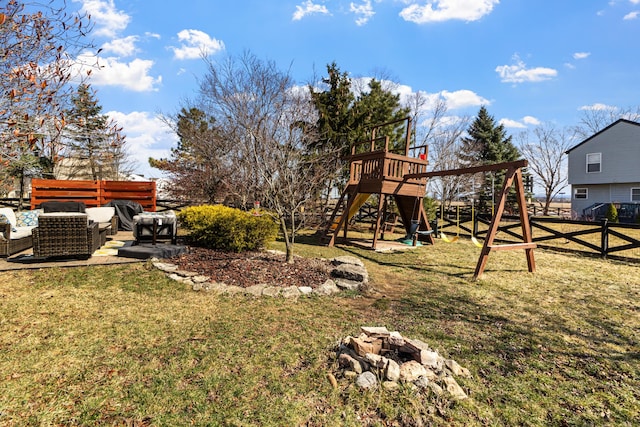 view of yard featuring an outdoor fire pit, a playground, a patio, and fence