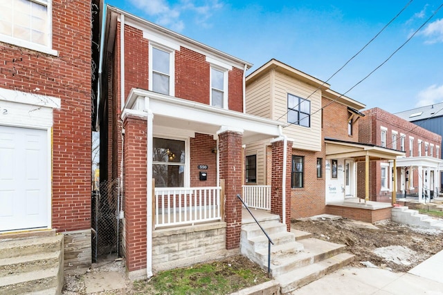 multi unit property with brick siding and a porch