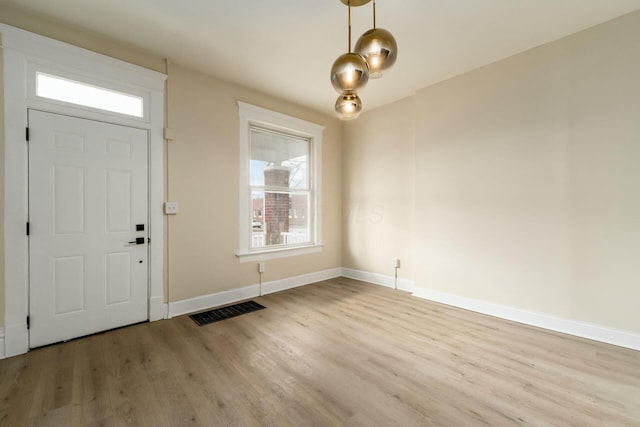 entryway with visible vents, baseboards, and wood finished floors