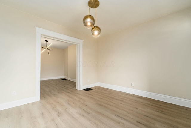 empty room with visible vents, baseboards, and light wood-style flooring