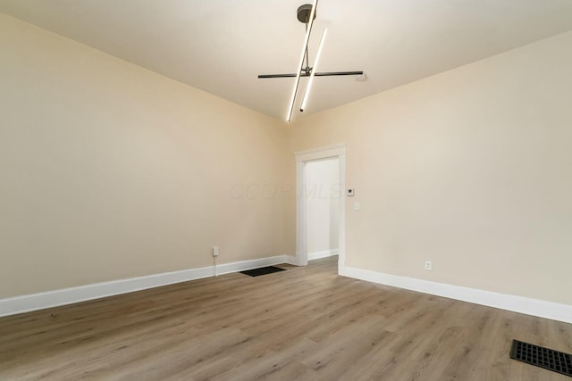 unfurnished room with baseboards, visible vents, and light wood finished floors