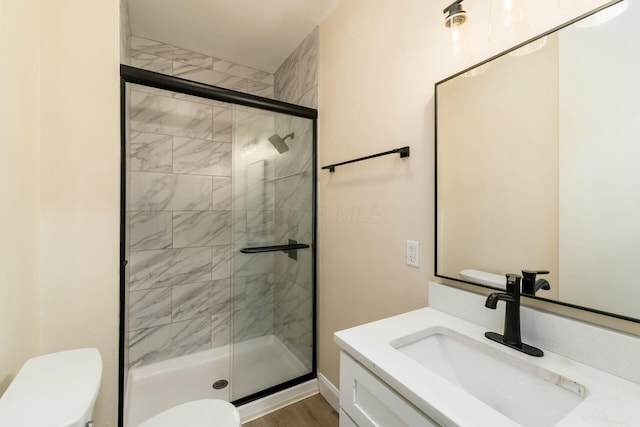 full bath featuring a stall shower, toilet, and vanity