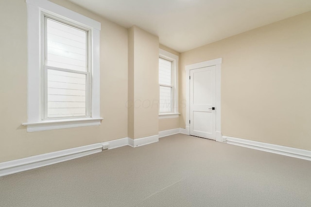 carpeted spare room featuring baseboards