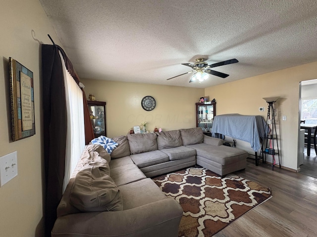 living area with dark wood finished floors, a textured ceiling, and ceiling fan