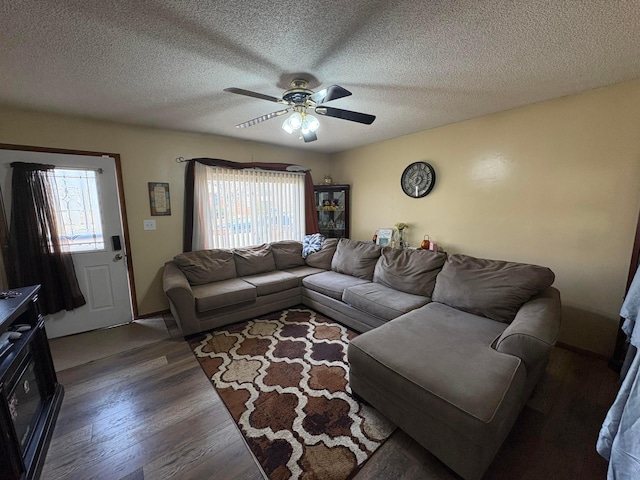 living room featuring a textured ceiling, a healthy amount of sunlight, wood finished floors, and a ceiling fan