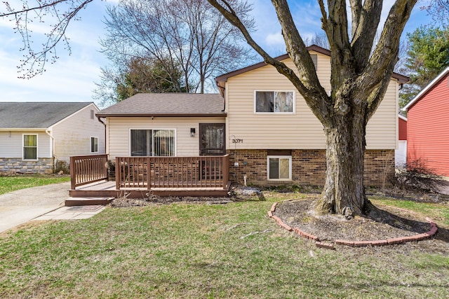 back of property featuring a lawn, a wooden deck, and roof with shingles