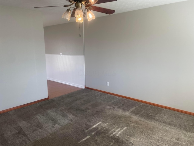 spare room with carpet flooring, baseboards, and ceiling fan