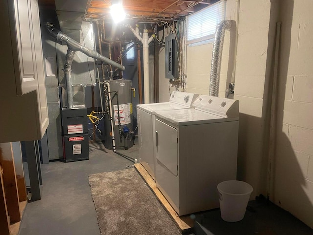 washroom featuring electric panel, laundry area, gas water heater, and washer and clothes dryer