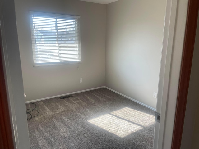 unfurnished room with visible vents, carpet floors, and baseboards