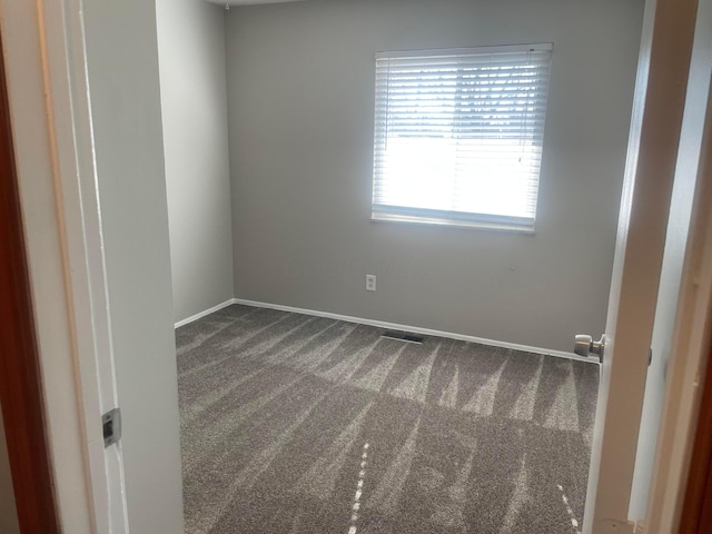 unfurnished room with carpet flooring and baseboards