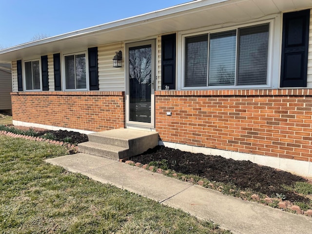 view of exterior entry featuring brick siding