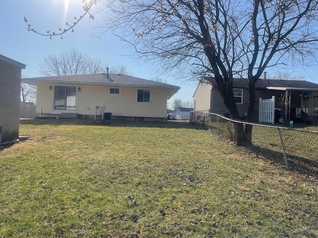 rear view of house with a lawn, fence private yard, and central AC