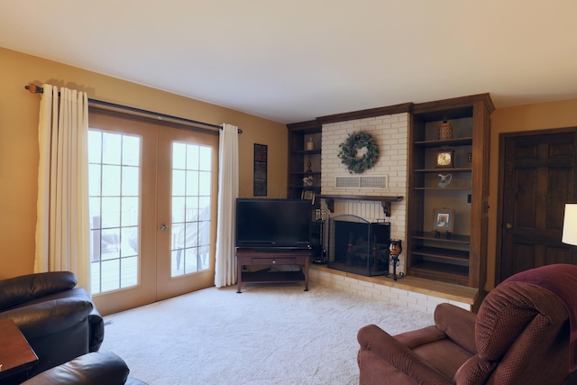 carpeted living area with a fireplace, visible vents, and french doors