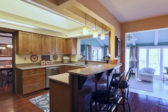 kitchen with a sink, dishwasher, brown cabinets, a peninsula, and dark wood-style flooring