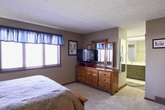 bedroom featuring a textured ceiling, baseboards, visible vents, and light carpet