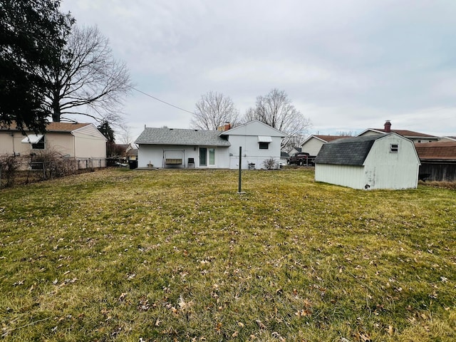 view of yard featuring an outbuilding, fence, and a shed