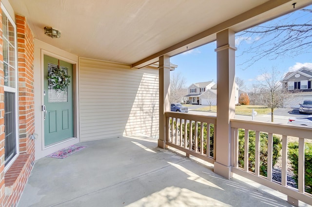 balcony featuring covered porch and a residential view