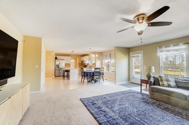 living room with light carpet, baseboards, and ceiling fan