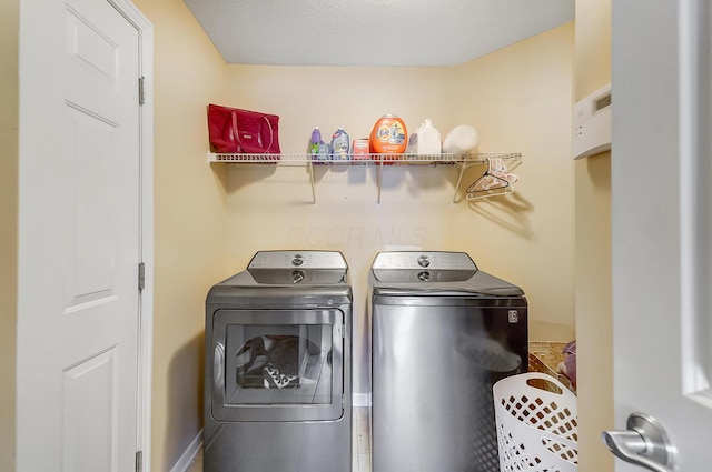 washroom featuring laundry area, baseboards, and independent washer and dryer