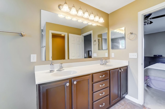 ensuite bathroom featuring a sink, connected bathroom, double vanity, and tile patterned floors