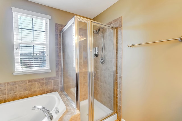 full bathroom with plenty of natural light, a stall shower, and a bath