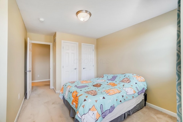 bedroom with light carpet and baseboards