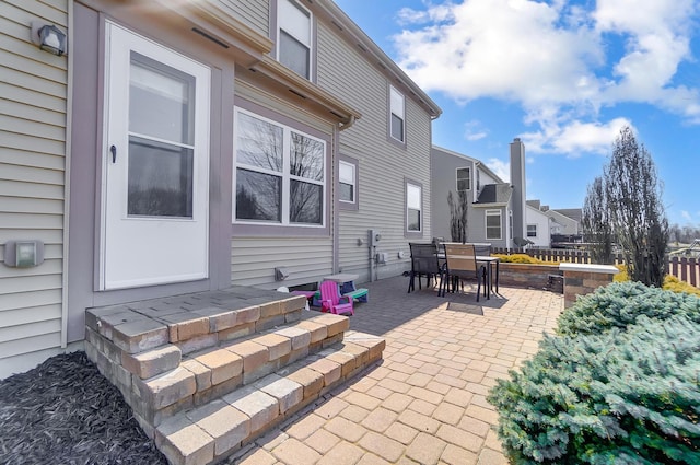 view of patio / terrace featuring outdoor dining space, fence, and a residential view