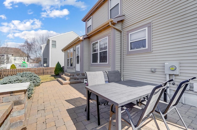 view of patio featuring entry steps, outdoor dining space, and fence